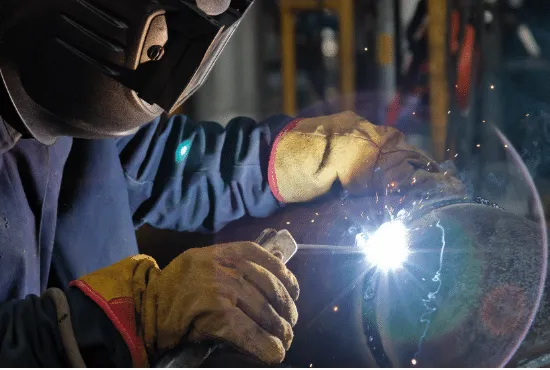 Technician welding a water chiller heat exchanger component in the factory